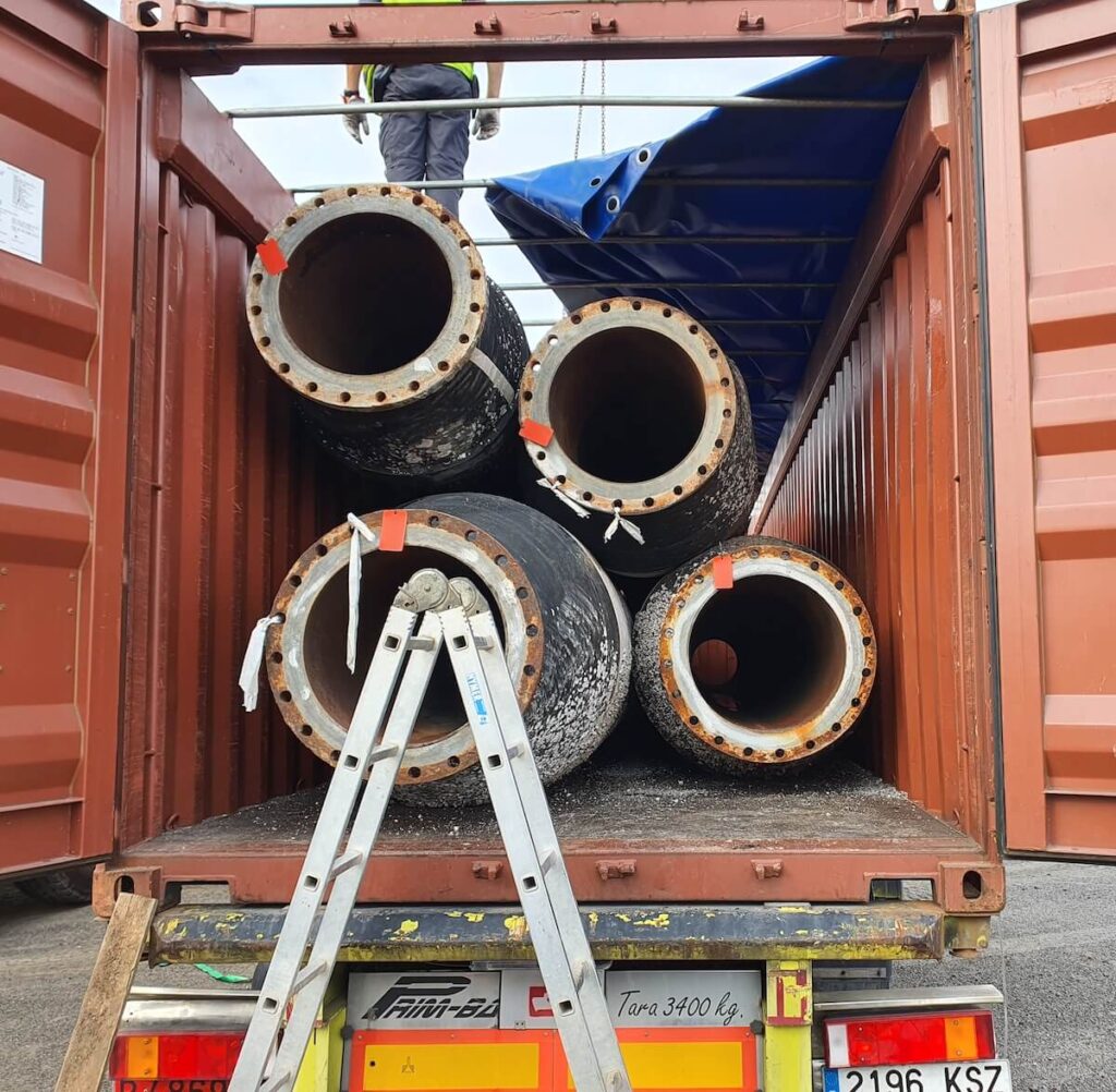 Baggerslangen laden voor transport in container Baggerslangen laden voor transport in container